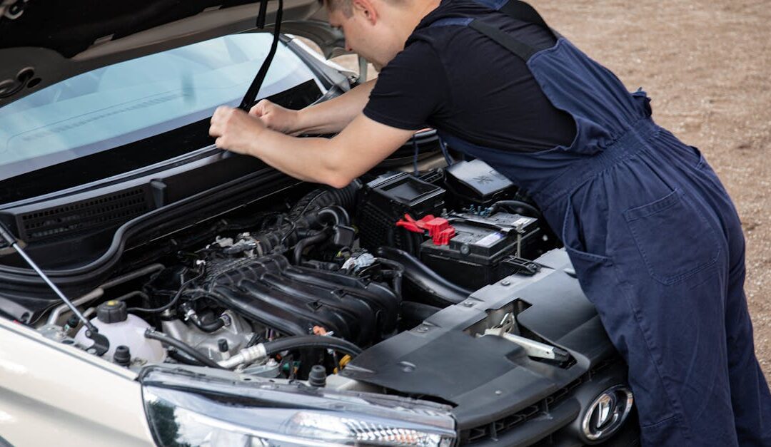 Mechanic working on a car engine with hood open, showcasing automotive repair skills.