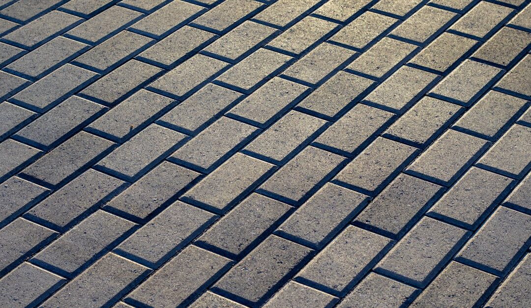 Sunlit outdoor stone pavement with a uniform brick pattern, ideal for backgrounds and architecture projects.