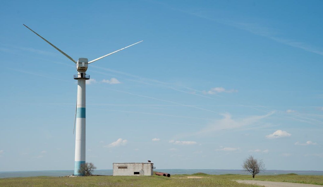 A solitary wind turbine stands amidst a grassland in Kalmykia, Russia, under a clear blue sky.