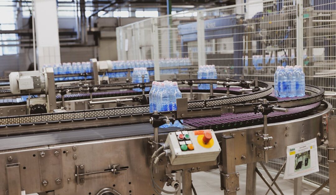 Water bottles being processed on an automated conveyor in a modern factory setting.