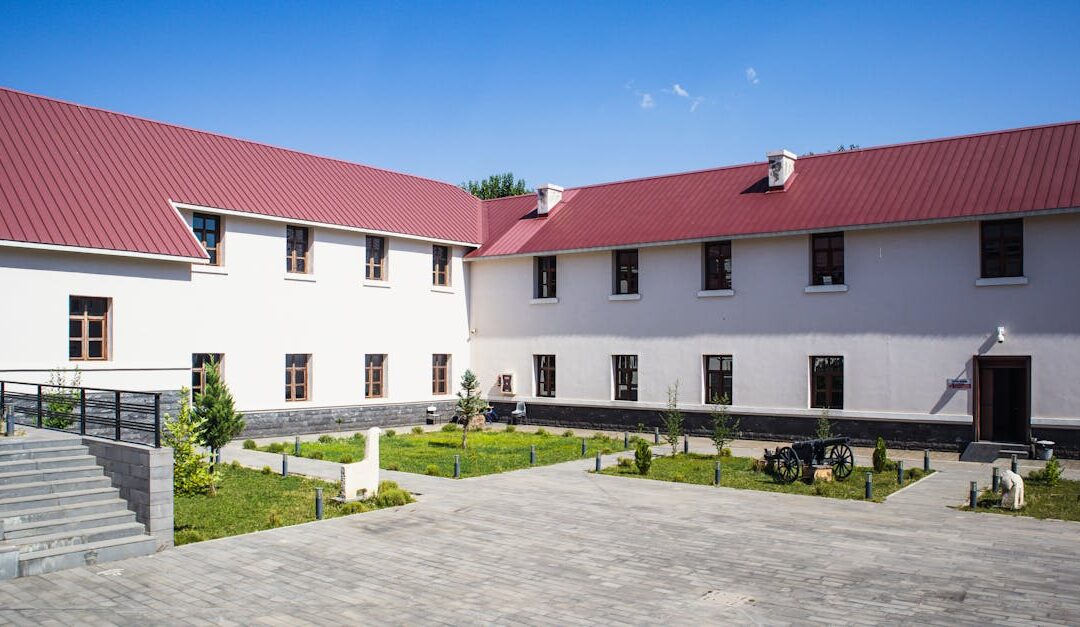 A contemporary building with a red roof in Tunceli, Türkiye under clear blue skies.
