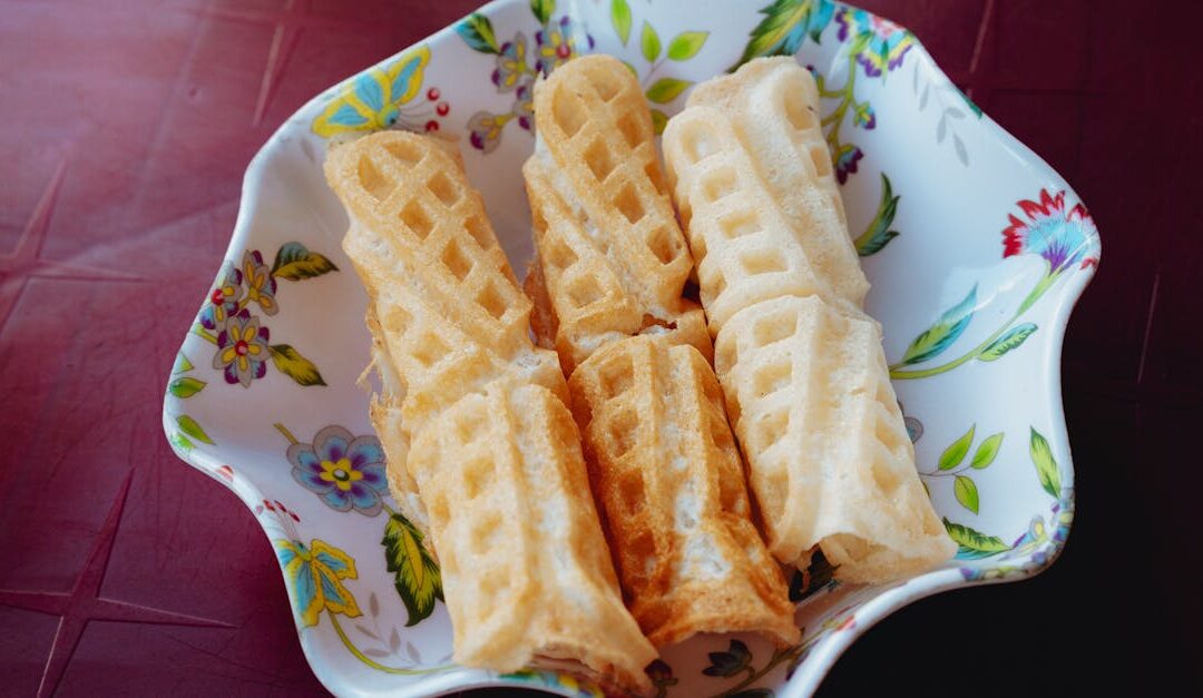 Crispy waffle rolls served in a decorative floral bowl, perfect for a sweet snack.