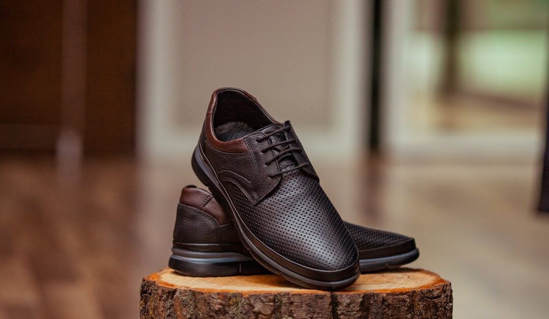 Stylish perforated leather shoes displayed elegantly on a rustic wooden stump indoors.