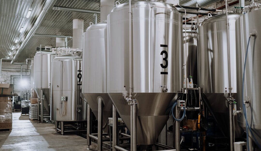 Interior view of a modern brewery showcasing stainless steel fermentation tanks.