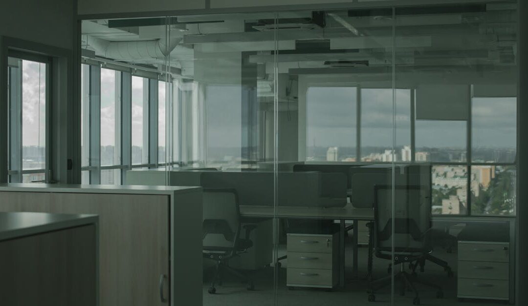 Spacious empty office with glass walls and city views, ideal for modern workspace settings.