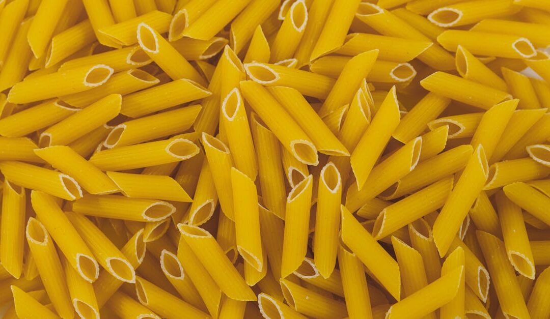 High-resolution close-up of raw penne pasta showing its unique texture and shape.