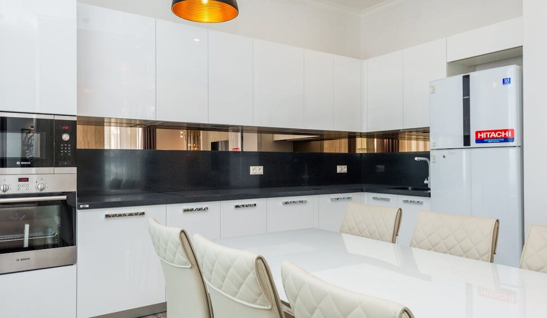 A clean, modern kitchen with white cabinets and a dining area.