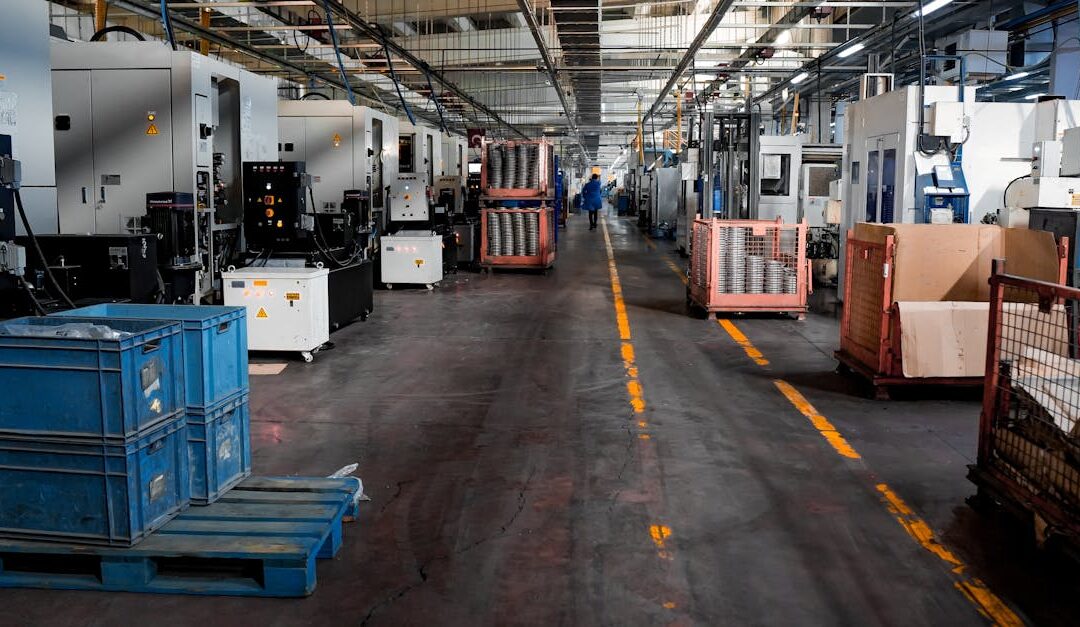 Vast industrial factory floor with machinery, crates, and structured workstations.