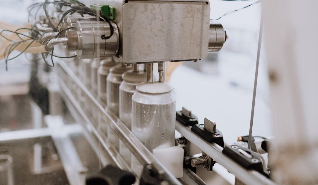 Close-up of an automated can filling machine in a beverage production line.