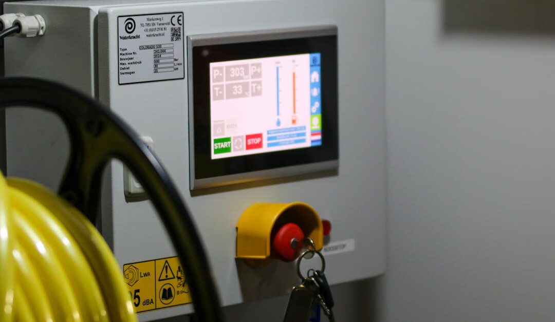 Close-up of an industrial control panel displaying safety features and a digital screen.