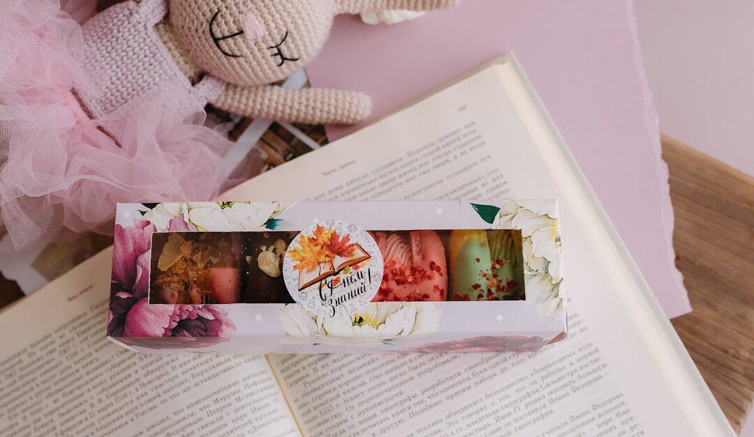 Sweet pastel macarons in a floral box with a cute handmade bunny on a book.