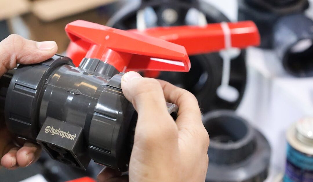 Close-up of hands examining a Hydroplast industrial valve at a trade expo.