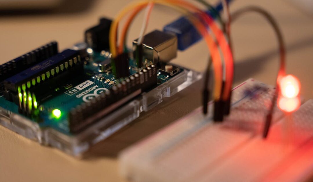 Close-up of Arduino microcontroller connected to a breadboard with a glowing LED.