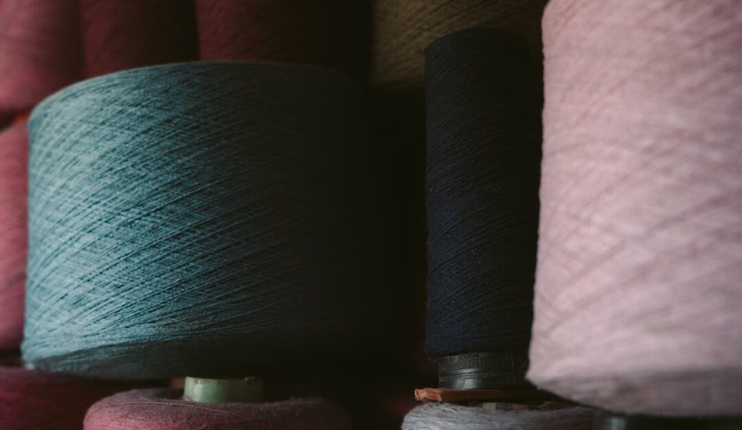 Colorful yarn spools stacked in a Oaxaca textile workshop, showcasing traditional craft materials.