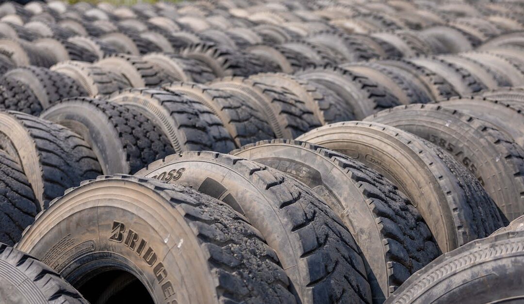 A detailed view of numerous stacked used tires in an outdoor industrial environment.