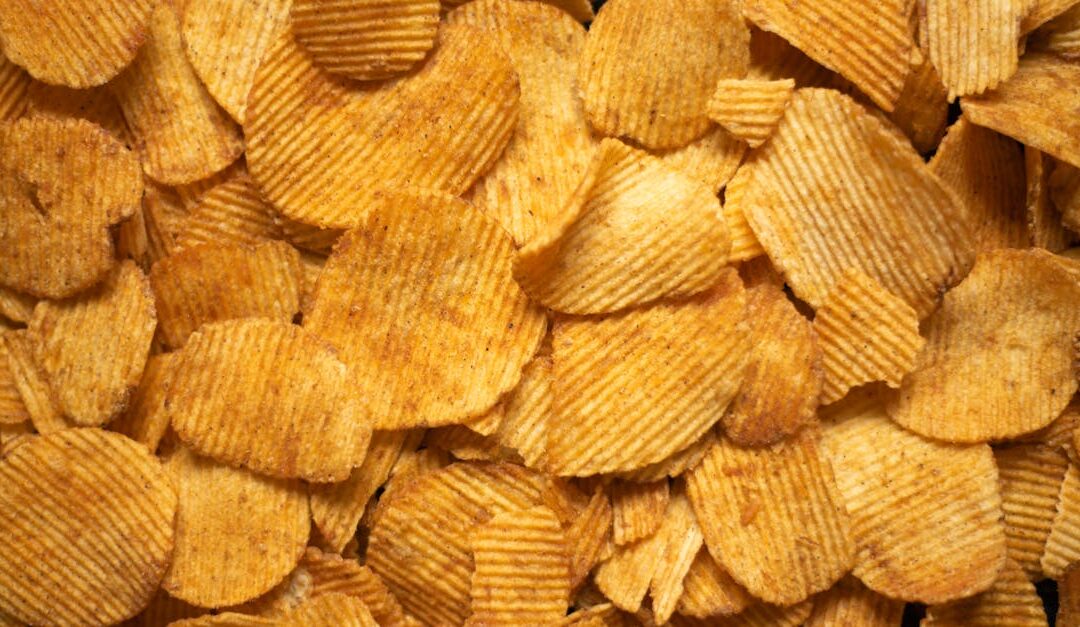 From above heap of crispy golden appetizing potato chips scattered as abstract background
