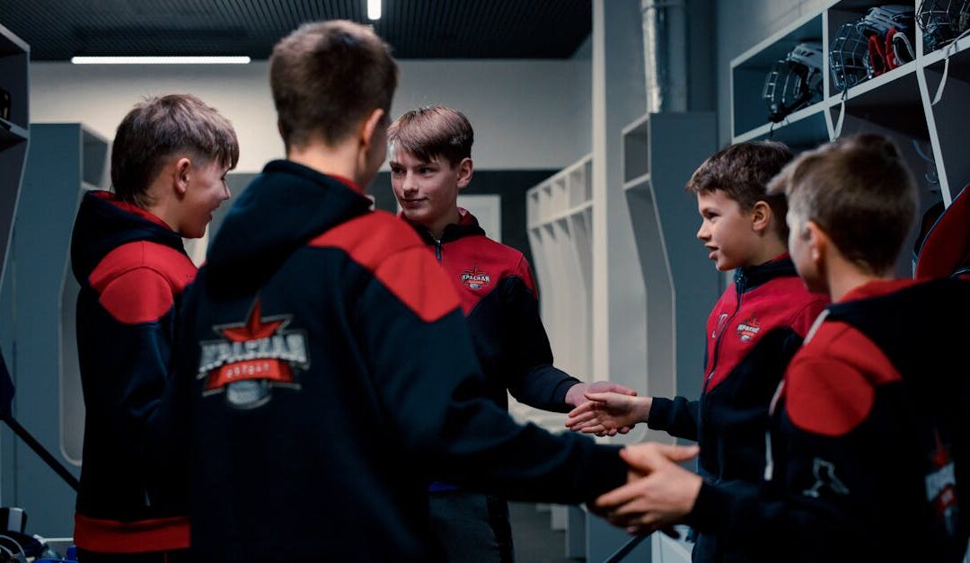 A group of teenage boys in a locker room displaying team spirit before a game.