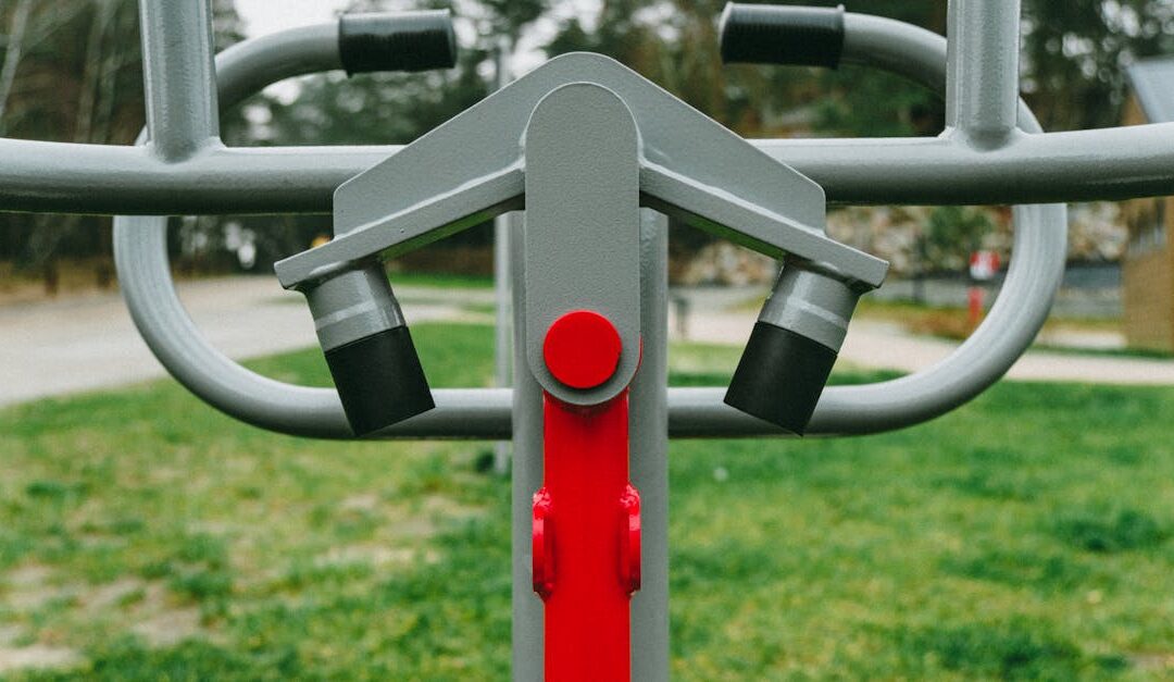 Outdoor exercise equipment with focus on red detail, set in a lush Polish park during spring.