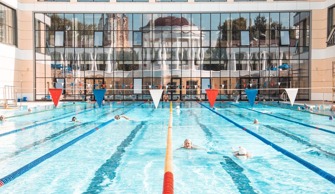 Vibrant swimming pool scene with clear reflections on a building facade, capturing leisure and activity.