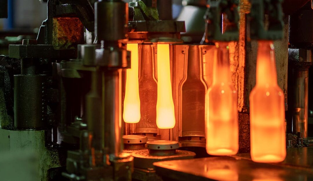 Close-up of molten glass bottles being shaped in a factory machine in Dar es Salaam, Tanzania.