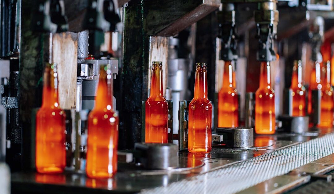 Glass bottles on a production line in a modern glass factory, showcasing industrial automation.