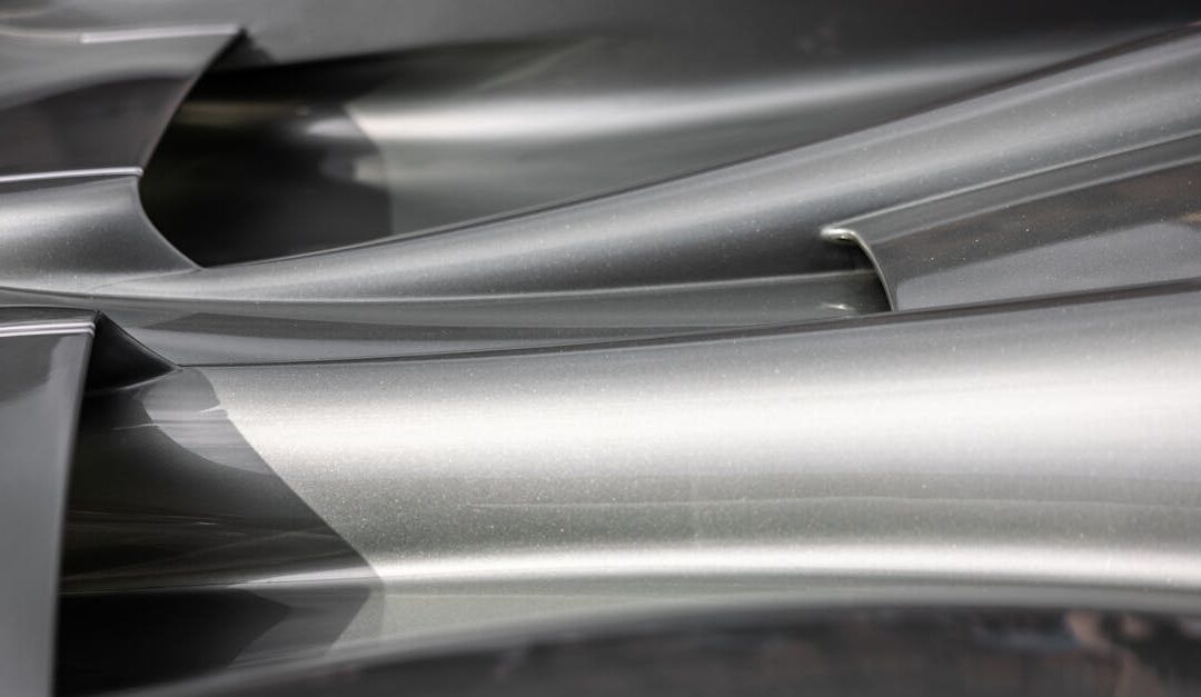 Close-up of sleek abstract metal surfaces with smooth curves and reflections.