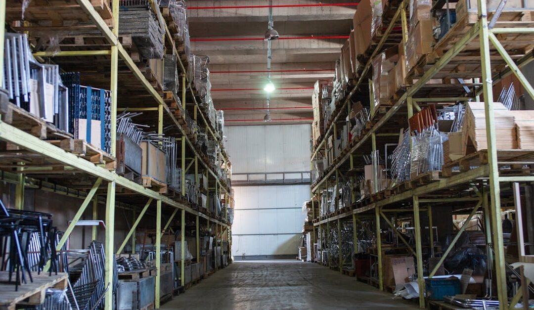 Wide aisle in a spacious warehouse filled with industrial metal shelving units.
