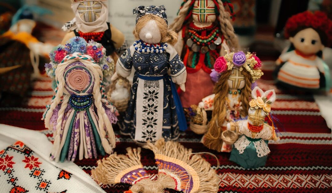 A collection of colorful handmade dolls displayed on embroidered fabric, showcasing cultural artistry.