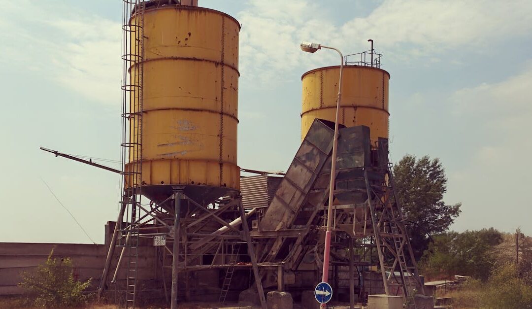 Abandoned yellow silos in a desolate industrial area with a dystopian feel.