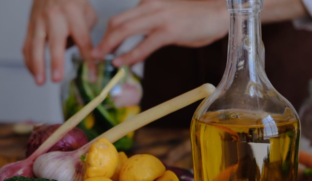 Hands preparing vegetables with olive oil, garlic, and squash in a kitchen setting.
