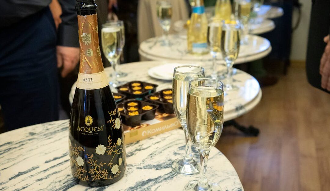 Set of bottles with alcohol drinks and wineglasses placed on tables near snacks during event celebration in company in r