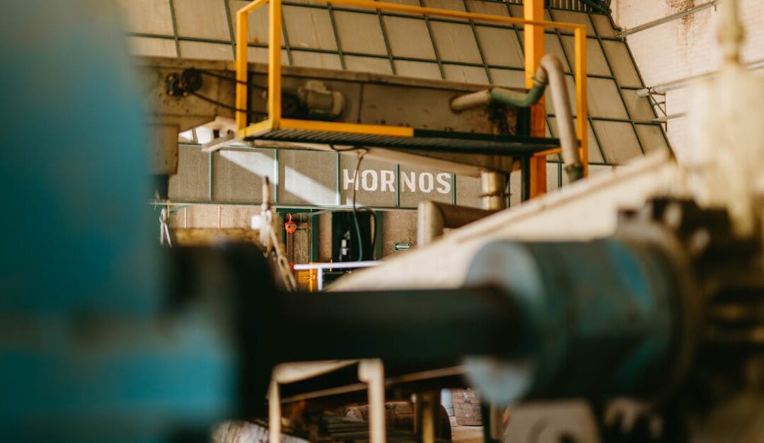 Close-up of heavy machinery inside an industrial factory with focus on ironworks and conveyor systems.